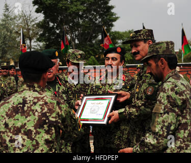 Afghan National Army Private Mohammed Khaili, der 100.000. BWC-Diplom durchlaufen, Alphabetisierung, erhält eine Plakette und Stift in Kabul Military Training Center in Kabul, Afghanistan, 28. Juli 2011, in Anerkennung der afghanischen nationalen Sicherheitskräfte Errungenschaften im Bereich der Bildung und Alphabetisierung. Grundsätzliche Krieger Ausbildung Kandak 162 absolvierte 1.287 Soldaten, all denen weiterhin militärische und Alphabetisierung in verschiedenen Afghan National Army Zweig Schulen oder konsolidiert Fielding Cener in Kabul. (Foto: U.S. Navy Petty Officer 2. Klasse Michael James/freigegeben) 100,00 Stockfoto