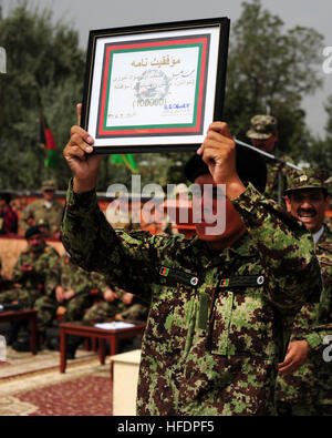 Afghan National Army Private Mohammed Khaili, der 100.000. BWC-Diplom durchlaufen, Alphabetisierung, erhält eine Plakette und Stift in Kabul Military Training Center in Kabul, Afghanistan, 28. Juli 2011, in Anerkennung der afghanischen nationalen Sicherheitskräfte Errungenschaften im Bereich der Bildung und Alphabetisierung. Grundsätzliche Krieger Ausbildung Kandak 162 absolvierte 1.287 Soldaten, all denen weiterhin militärische und Alphabetisierung in verschiedenen Afghan National Army Zweig Schulen oder konsolidiert Fielding Cener in Kabul. (Foto: U.S. Navy Petty Officer 2. Klasse Michael James/freigegeben) 100,00 Stockfoto