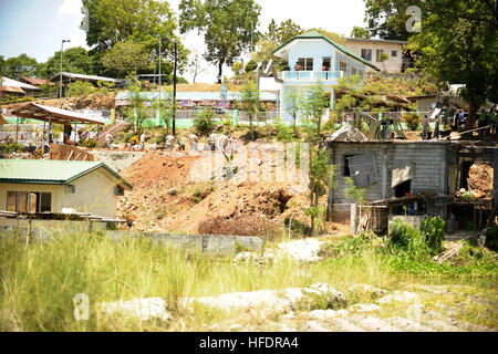 Rasen und Asche sind das einzige, was bleibt von der alten statt Barangay wirkt jetzt oben am wiederbelebten Barangay und Bau der neuen Grundschule statt. Philippinische und US Air Force Ingenieure arbeiten zusammen, um ein neues Schulhaus für die lokale Gemeinschaft zu bauen. Eines der acht Ingenieurprojekten Bürgerschaftliches Engagement (ENCAP) wird durchgeführt von kombinierten/Joint zivil-militärische Operationen Task Force (CJCMOTF) Einheiten zur Unterstützung der Übung Balikatan 2013.Balikatan 2013 (BK13) eine jährliche Philippine-US bilateralen ist statt Schulhaus ausüben. Humanitäre Hilfe und training act Stockfoto