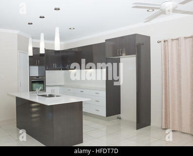 neue, moderne Küche mit Insel-Bank und hängende Leuchten Stockfoto