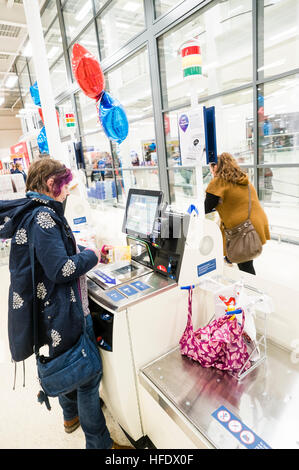 Supermarktkasse: ein Frau-Shopper mit der SB-Kasse in der Tesco-Supermarkt-Superstore, Aberystwyth Wales UK (am Tag Eröffnung des Ladens 24. November 2016) Stockfoto