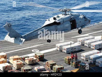 040423-N-7408M-004-Atlantik (23. April 2004) - ein SH-60F Seahawk zugewiesen "Dreizack" der Hubschrauber Anti-Submarine Squadron drei (HS-3) schwebt knapp über dem Flugdeck der USS Enterprise (CVN-65) mit zwei Besatzungsmitgliedern legen eine Waffen-Kiste. Die Waffen-Kisten werden auf dem Flugzeugträger USS John F. Kennedy (CV-67) übertragen.  Enterprise ist derzeit im Gange Träger Qualifikationen (CQ) durchführen. US Navy Foto des Fotografen Mate Airman Justin McGarry. (FREIGEGEBEN) UNS Marine 040423-N-7408M-004, die eine SH-60F Seahawk knapp über dem Flugdeck der USS Enterprise (CVN-65 schwebt) Stockfoto