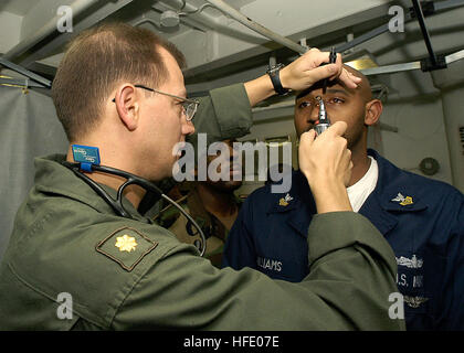 040531-N-9630B-025 arabischen Golf (31. Mai 2004) - US Navy Fliegerarzt, Lt. CMdR Scott Carlson von Downers Grove, Illinois, führt und Augen-Untersuchung auf Operation Spezialist 1. Klasse Naron Williams von Jacksonville, Florida, in des Schiffs medizinischen Abteilung im Rahmen eines medizinischen Reihenuntersuchung an Bord der USS George Washington (CVN-73).  Der Norfolk, VA. nuclear powered Flugzeugträger ist auf eine geplante Bereitstellung zur Unterstützung der Operation Iraqi Freedom (OIF). US Navy Foto vom Fotografen Mate Flieger Robert Brooks (freigegeben) US Navy 040531-N-9630B-025 US Navy Fliegerarzt, Lt. Cmdr. Stockfoto