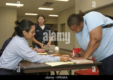 040915-N-4204E-021 Pensacola, Florida (15. September 2004) - Flieger Kiesha Nanchett, Student, Naval Air technische Training Center (NATTC) zugewiesen, Pensacola resident Sanda Robinson mit der Rotkreuz-Registrierung im Florida Westhigh School Tierheim hilft. 49 Schüler und drei Lehrer gaben Unterstützung im Tierheim als Hurrikan Ivan Florida Pfannenstiel näherte. Ivan bildete Landfall an Gulf Shores, Alabama, um etwa 0315 EST mit Windgeschwindigkeiten von 130 MPH. zwölf Todesfälle auf Ivan Schuld sind, wie es an Land kam. Foto: U.S. Navy des Fotografen Mate 2. Klasse Mark A. Ebert (frei) Stockfoto