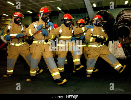 041207-N-5345W-033-Persischen Golf (7. Dezember 2004) Ð Feuer-Team-Mitglieder Ansatz einer simulierten Flugzeug Feuer im Hangar Bucht an Bord der Flugzeugträger der Nimitz-Klasse USS Harry S. Truman (CVN-75) während eines Bohrers allgemeine Viertel (GQ). Derzeit sind Flugzeuge aus Carrier Air Wing drei (CVW-3) begonnen an Bord Truman Luftnahunterstützung Bereitstellung und Durchführung von Intelligenz, Überwachung und Aufklärungsmissionen im laufenden Betrieb über den Irak. Trumans Carrier Strike Zehner-Gruppe (CSG-10) und eingeschifften CVW-3 befinden sich auf einer regelmäßigen Bereitstellung zur Unterstützung der globalen Krieg gegen den Terrorismus. U.S Stockfoto