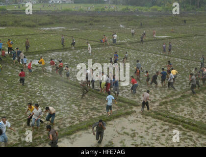 050101-N-1229B-177-Sumatra, Indonesien (1. Januar 2005) Ð indonesische Flüchtlinge versammeln sich unter einen sich nähernden Hubschrauber, Lebensmittel und Vorräte zu erhalten. Seahawk Flugzeuge Hubschrauber Anti-Submarine Squadron 2 (HS-2) ÒGolden FalconsÓ an Bord der USS Abraham Lincoln (CVN-72) in Angriff genommen, ist die Verteilung humanitären Hilfe während der Insel Sumatra.  Die Abraham Lincoln Carrier Strike Group ist derzeit in den Indischen Ozean aus dem Wasser von Indonesien und Thailand. Foto: U.S. Navy PhotographerÕs Mate Airman Patrick M. Bonafede (freigegeben) US Navy 050101-N-1229B-177 indonesische Flüchtlinge gat Stockfoto