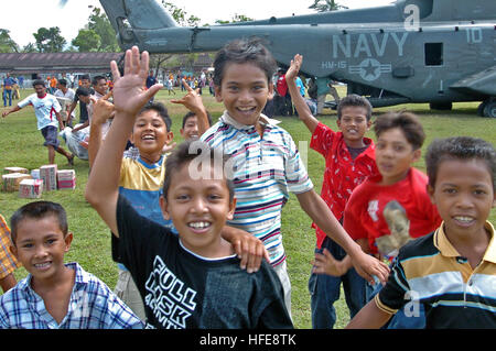 050123-N-9885M-136 Lamno, Indonesien - indonesische Kinder versammeln sich um ein MH-53E Sea Dragon-Hubschrauber als Besatzungsmitglieder der Hubschrauber Mine Gegenmaßnahmen Geschwader 15 (HM-15) Hilfsgüter auszuladen.  Die Matrosen der HM-15 werden zugewiesen, der USS Essex (LHD-2), derzeit im Indischen Ozean vor den Gewässern Indonesiens zur Unterstützung der Operation Unified Hilfe, humanitäre Operation Aufwand im Zuge der Tsunami, der Süd-Ost Asien getroffen. U.S. Navy Photo by PhotographerÕs Mate 1. Klasse Alan D. Monyelle uns Marine 050123-N-9885M-136 indonesische Kinder versammeln sich um ein MH-53E Sea Stockfoto