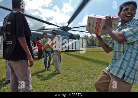 050123-N-9885M-250 Lamno, Indonesien - Indonesier tragen Kisten mit Nudeln aus dem Helikopter MH-53E Sea Dragon Besatzungsmitglieder der Hubschrauber Mine Gegenmaßnahmen Geschwader 15 (HM-15) Hilfsgüter auszuladen.  Die Matrosen der HM-15 werden zugewiesen, der USS Essex (LHD-2), derzeit im Indischen Ozean vor den Gewässern Indonesiens zur Unterstützung der Operation Unified Hilfe, humanitäre Operation Aufwand im Zuge der Tsunami, der Süd-Ost Asien getroffen. U.S. Navy Photo by PhotographerÕs Mate 1. Klasse Alan D. Monyelle uns Marine 050123-N-9885M-250 indonesischen Bürger Kisten tragen Stockfoto