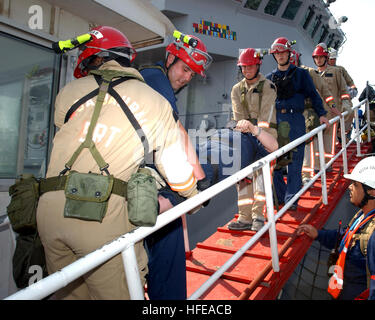 050228-N-9563N-003 Manama, Bahrain (28. Februar 2005) - Mitglieder des Naval Support Activity (NSA) Bahrain Emergency Response Team (ERT) trägt einen simulierten Unfall zu einem bestimmten medizinischen Bereich aus dem Bergwerk Gegenmaßnahme Schiff USS Cardinal (MHC-60) während des Trainings Wüste Seemann 2005. Übung-Wüste Seemann ist eine jährlichen zweiwöchigen Übung um sicherzustellen, dass Notfallhilfe Bemühungen lokaler bahrainische Direktionen im tatsächlichen Notfall gut abgestimmt sind. US Navy Foto vom Fotografen der 2. Klasse Phillip A. Nickerson Jr. (freigegeben) US Navy 050228-N-9563N-003 Mitglieder des Naval Support Act Mate Stockfoto