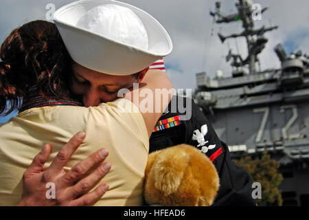 050301-N-4166B-030 San Diego, Kalifornien (1. März 2005) - A Sailor zugewiesen Carrier Air Wing Two (CVW-2), umarmt seine Frau nach der Rückkehr nach San Diego, Kalifornien, von einer Einrichtung an Bord der Flugzeugträger der Nimitz-Klasse USS Abraham Lincoln (CVN-72). Lincoln und CVW-2 unterstützt Operation Unified Assistance, die humanitären Hilfsmaßnahmen zugunsten der Opfer der Tsunami-Katastrophe, die Südostasien während ihres Einsatzes des westlichen Pazifik geschlagen. Lincoln zog in San Diego, Drop-off die Matrosen und Marines CVW-2 zugewiesen und dann machen die Durchfuhr die Küste hinauf zu ihrem Heimathafen von Everett, Washington Stockfoto