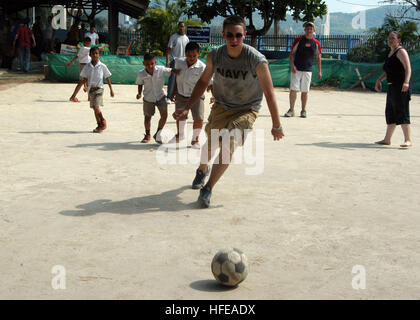 050301-N-8955H-096 Kamala, Thailand (1. März 2005) - Information Systems Techniker Seemann Apprentice Tyler Montgomery von Dayton, Ohio, spielt Fußball mit Studenten während einem ehrenamtlichen Projekt in Kamala Grundschule in Kamala, Thailand. USS Blue Ridge, Flaggschiff der siebten US-Flotte, war bei einem geplanten Hafen-Besuch in Phuket, Thailand. Während im Hafen des Schiffs etwa 1.000 Matrosen, Marines und Mitarbeiter Community Serviceprojekte durchgeführt und erfuhren mehr über die thailändische Kultur. US Navy Foto vom Fotografen der 1. Klasse Novia E. Harrington (freigegeben) uns Marine 05030 Mate Stockfoto