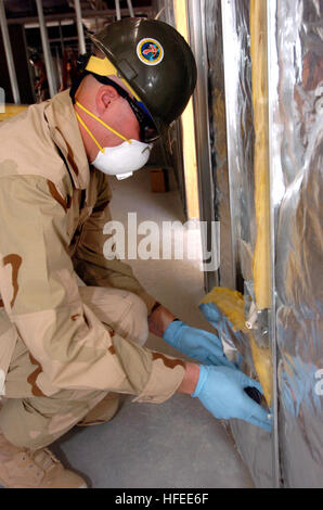 022706-N-4267W-006 Camp Arifjan, Kuwait (27. Februar 2006) - fügt Builder Constructionman William Kimbril Isolierung in Baracken, die Seabees zugewiesen, Naval Mobile Bau-Bataillon 7 (NMCB-7) und NMCB-21 derzeit umgestalten, um das Leben für die Soldaten, Matrosen, Flieger und Marines ein wenig komfortabler zu machen. NMCB-7 und NMCB-21 arbeiten zusammen zur Unterstützung der 3. Armee Coalition Forces Land Component Command. Foto: U.S. Navy PhotographerÕs Mate 3. Klasse Paul D. Williams (freigegeben) US Navy 022706-N-4267W-006-Generator Constructionman William Kimbril fügt Isolierung int Stockfoto