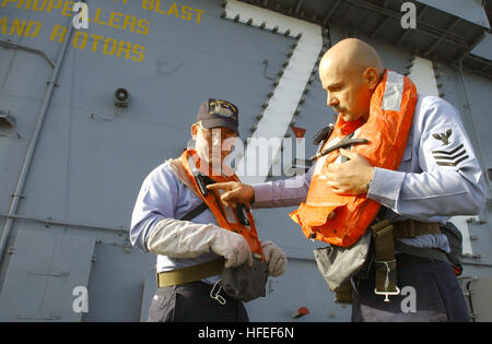 030124-N-9769P-027 an Bord der USS John C. Stennis (CVN-74) 23. Januar 2003--Luftfahrt Bootsmann's Mate 1. Klasse Sergio Hernandez aus Los Angeles, Kalifornien, erklärt Aviation Boatswain Mate Airman Mike Mares von Palm Springs, Kalifornien, die Verfahren um eine aufblasbare Lebensretter während einer Hingabe Schiff Trainingsszenario an Bord des Flugzeugträgers don.  Die Stennis ist im Hafen Òfast CruiseÓ Fortbildungsmaßnahmen vor Beginn Probefahrten durchführen. Ein Òfast CruiseÓ simuliert ein Schiff auf hoher See, während tatsächlich an der Pier angedockt wird.  US Navy Foto vom Fotografen Mate 2. Klasse Jayme Pastoric. Stockfoto