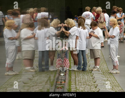 Die Besucher nehmen an der Vietnam Veterans Memorial Wall in Washington, D.C., die 57.939 Männer und Frauen ehrt, die während des Vietnamkriegs starben oder vermisst wurden. Das Denkmal umfasst die Mauer, die Statue der drei Soldaten, den Fahnenmast und das Vietnam Women's Memorial. Stockfoto