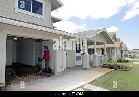 040324-N-3228G-009 Pearl Harbor, Hawaii (24. März 2004) - entspannen Navy Familienmitglieder auf ihren Rasen, während Aufsteiger ihren Hausrat in ihr neues Zuhause auf Ford Island liefern. Das Neubaugebiet ist Teil eines $ 35 Millionen-Projekts zu entwerfen und zu konstruieren, 140 Häuser auf Ford Island und 30 Häuser bei Radford Terrasse. Die Häuser sind drei und vier-Zimmer-Einheiten als Maisonette und Quad-Gebäude angeordnet. Sie verfügen über Annehmlichkeiten wie Metallrahmen, Garagen, zentrale Klimaanlage, solar-Warmwasser-Systeme, moderne Küchen mit energiesparenden Geräten und Full-Size-Waschmaschinen und Trockner.  Die ne Stockfoto