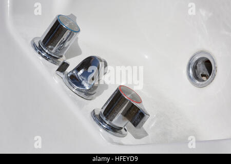 Alte Armaturen auf schmutzige weiße Wanne. Stockfoto