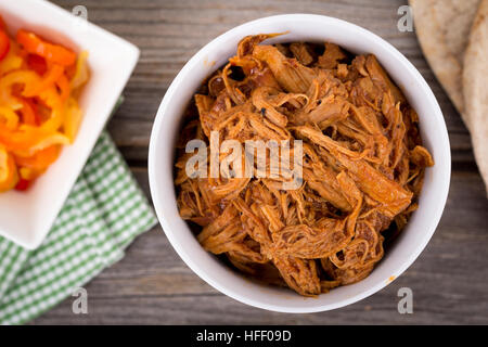 BBQ Schweinefleisch Schüssel über einem Holzbrett Tisch gezogen Stockfoto