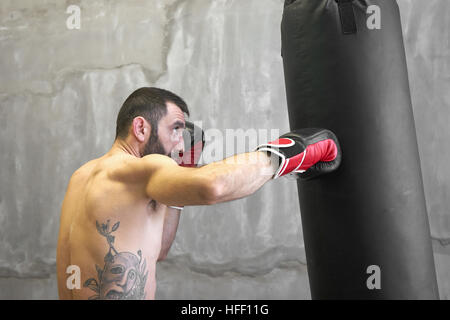 Boxer-Mann Übung mit Boxsack Stockfoto