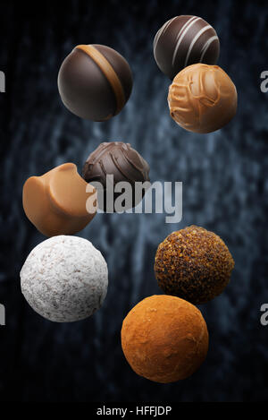 Sortierte Multi aromatisiert Pralinen vor einem dunklen Hintergrund schweben Stockfoto