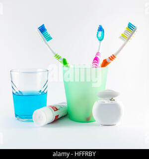 Multicolor Zahnbürsten, Zahnseide, Zahnpasta und Mundwasser auf weißem Hintergrund Stockfoto