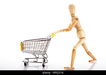 Gegliederte hölzerne Puppe schieben eines Einkaufswagens Stockfoto