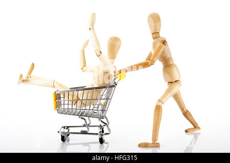 Gegliederte hölzerne Puppe schieben eines Einkaufswagens Stockfoto