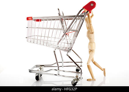 Gegliederte hölzerne Puppe schieben eines Einkaufswagens Stockfoto