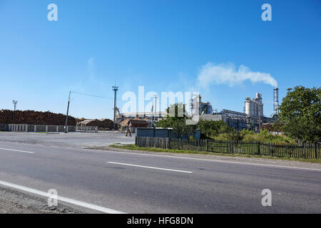 Holzfabrik mit rauchenden Schornsteinen. Stockfoto