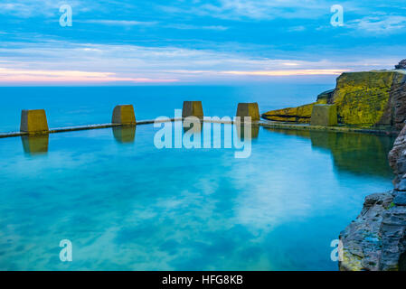 Negativer Bereich mit Wolken, die sich in einem Ozeanpool am Coogee Beach in Sydney in New South Wales, Australien, spiegeln Stockfoto