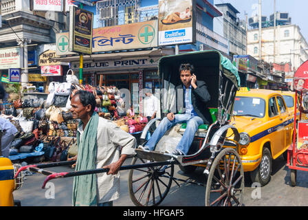 Kolkata (Calcutta, Kalkutta): zog Rikscha, Mann mit Handy als Passagier, West-Bengalen, Westbengalen, Indien Stockfoto
