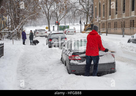 Montreal, CA - 12. Dezember 2016: Mann Reinigung sein Auto aus dem Schnee bei Schneefall im Winter. Stockfoto