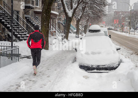 Montreal, CA - 12. Dezember 2016: Schneesturm in Montreal. Jogger auf der Saint-Joseph Avenue. Stockfoto