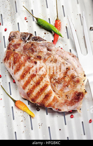 Gegrilltes Schweineschnitzel, Grill-Marken auf eine Aluminium-Grill mit Fleischgabel Stockfoto