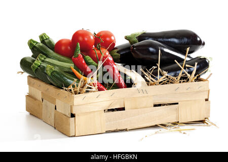 Korb mit Gemüse: Zucchini, Paprika, Tomaten und Auberginen auf Stroh Stockfoto