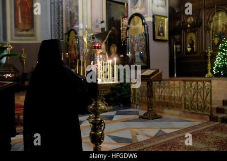 Russisch-orthodoxe Geistliche zünden Kerzen in der Kathedrale der Heiligen Dreifaltigkeit der Russischen kirchlichen Mission in Migrash HaRusim (Russisches Gelände) in West-Jerusalem Israel an Stockfoto