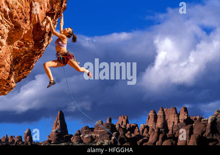 Weibliche Kletterer Dangeling vom Rand eines steilen Felsen-Berges. Stockfoto