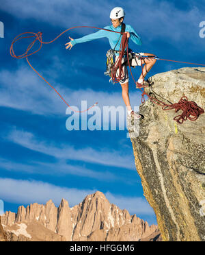 Weibliche Kletterer Dangeling vom Rand eines steilen Felsen-Berges. Stockfoto