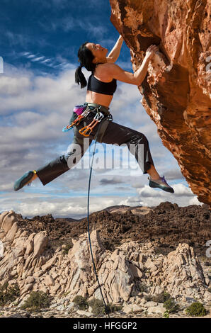 Weibliche asiatische Kletterer baumelt vom Rand für eine schwierige Klippe Stockfoto