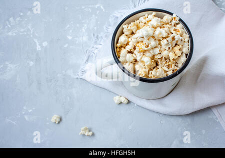 Süßen Karamell Popcorn in einem großen eisernen Kreis auf die konkrete grauen Hintergrund. Stockfoto