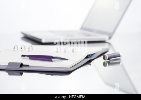 Geschäftsmann schreiben Sie eine kurze Notiz auf geöffneten Notizbuch mit Stift und Gläser. Stockfoto