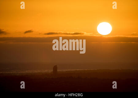 Sonnenaufgang über einer ländlichen walisischen Landschaft in der Nähe des Dorfes Rhosesmor und in Richtung Cheshire in England, mit Hanson Cement Works sichtbar, Flintshire, Wales, Großbritannien Stockfoto