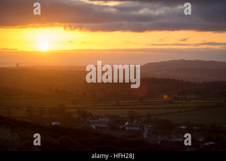 Sonnenaufgang über einer ländlichen walisischen Landschaft in der Nähe des Dorfes Rhosesmor und in Richtung Cheshire in England, mit Hanson Cement Works sichtbar, Flintshire, Wales, Großbritannien Stockfoto