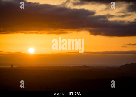 Sonnenaufgang über einer ländlichen walisischen Landschaft in der Nähe des Dorfes Rhosesmor und in Richtung Cheshire in England, mit Hanson Cement Works sichtbar, Flintshire, Wales, Großbritannien Stockfoto