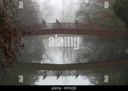 Chippenham, Großbritannien, 31. Dezember 2016. Winterwetter. Am letzten Tag des Jahres 2016 werden drei Männer mit ihren Mountainbikes an einem nebeligen Morgen über eine Brücke über den Fluss Avon in Chippenham, Wiltshire, gezeigt. Quelle: Lynchpics/Alamy Live News Stockfoto