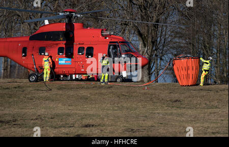 Kochel Am See, Deutschland. 2. Januar 2017. Ein Hubschrauber wird durch Einsatzkräfte vorbereitet, auf dem Jochberg-Berg in Kochel Am See, Deutschland, 2. Januar 2017 beginnen. Ein Bergsteiger verursachte ein Brand auf dem Jochberg-Berg. Etwa hundert Hektar Wald und Wiesen waren in Brand und die Feuerwehr konnte noch ein paar Tage um das Feuer zu löschen nach der Kreisverwaltung. Foto: Sven Hoppe/Dpa/Alamy Live News Stockfoto