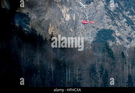 Kochel Am See, Deutschland. 2. Januar 2017. Ein Hubschrauber fliegen entlang des Jochberg-Bergs in Kochel Am See, Deutschland, 2. Januar 2017. Ein Bergsteiger verursachte ein Brand auf dem Jochberg-Berg. Etwa hundert Hektar Wald und Wiesen waren in Brand und die Feuerwehr konnte noch ein paar Tage um das Feuer zu löschen nach der Kreisverwaltung. Foto: Sven Hoppe/Dpa/Alamy Live News Stockfoto