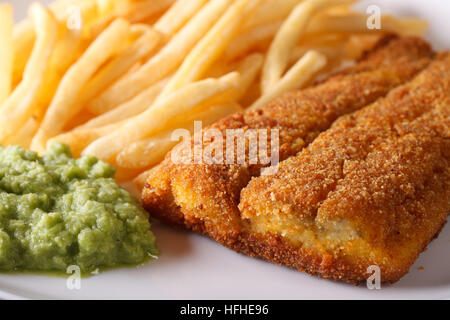 Englisch Essen: gebratene Fischfilets und Chips und Erbsen Püree Makro. horizontale Stockfoto