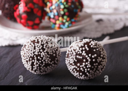 zwei Schoko-Cake Pops mit weißen Süßigkeiten Streusel Nahaufnahme auf dem Tisch. horizontale Stockfoto
