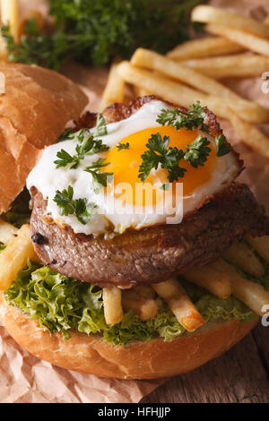 Sandwich mit Beefsteak, Spiegelei und Pommes frites Nahaufnahme. vertikale Stockfoto