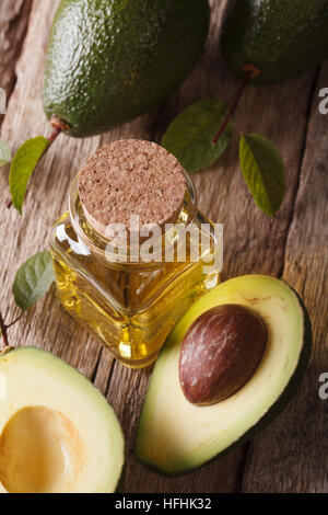 Avocado-Öl in eine Flasche aus Glas auf einem Holztisch Nahaufnahme, vertikale Ansicht von oben Stockfoto